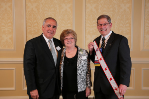 (L-R) MOAA Chairman of the Board, General John Tilelli, Jr. USA, Ret, Marilyn Casteel, and Columbia River Chapter President Dave Casteel displaying Level of Excellence banner presented by Gen Tilelli. The award presentation was at the Antlers Hotel in Colorado Springs, November 16, 2013.